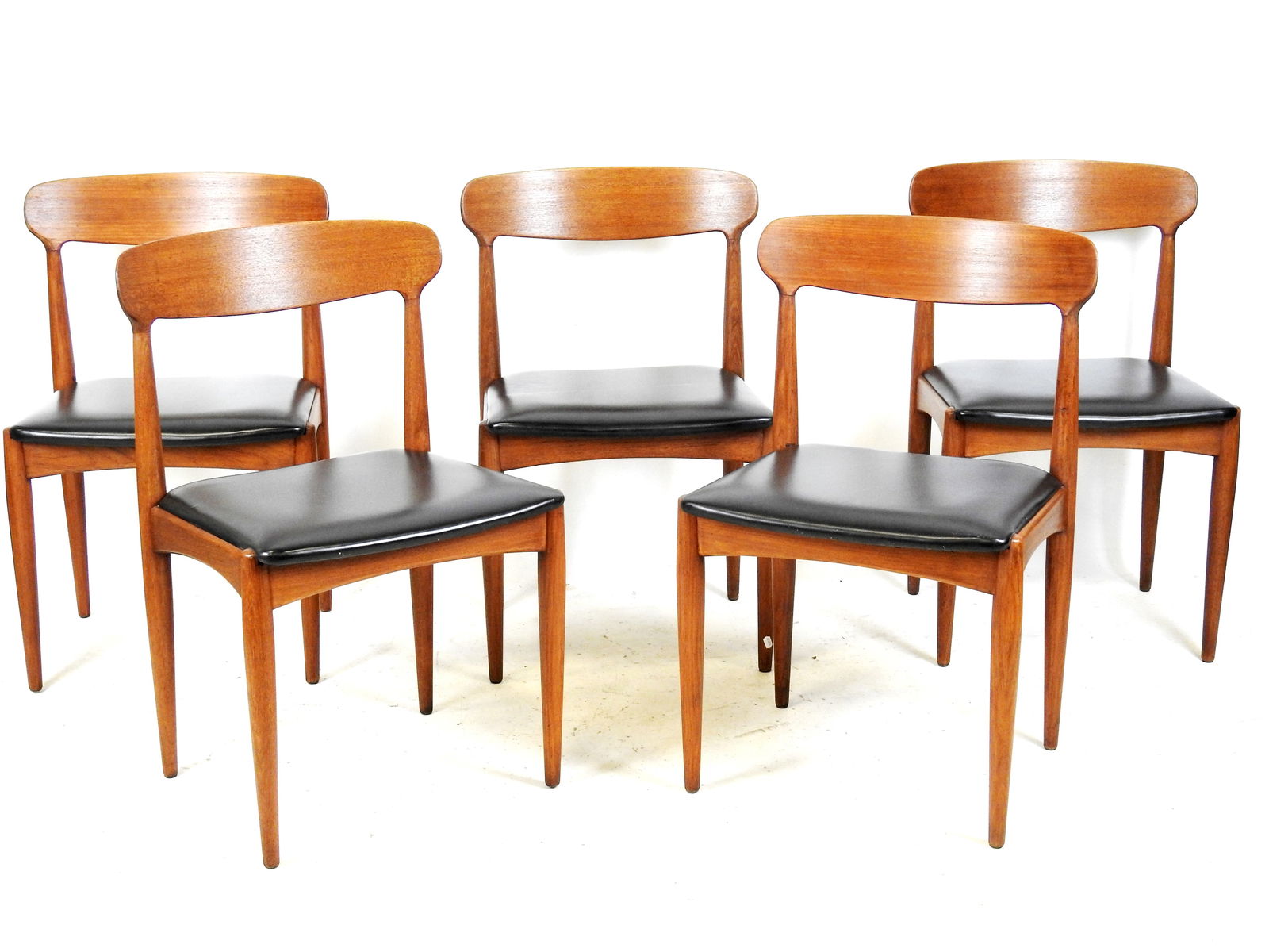 Johannes ANDERSEN (1903-1997) dans le gout : Cinq chaises en teck en simili-cuir. Etiquette de: Johannes ANDERSEN (1903-1997) dans le gout : Cinq chaises en teck en simili-cuir. Etiquette de l'editeur Uldum mobelfabrik et Danish control sur l'une. Cachet en creux Samcom. Haut : 78 cm. Long : 45