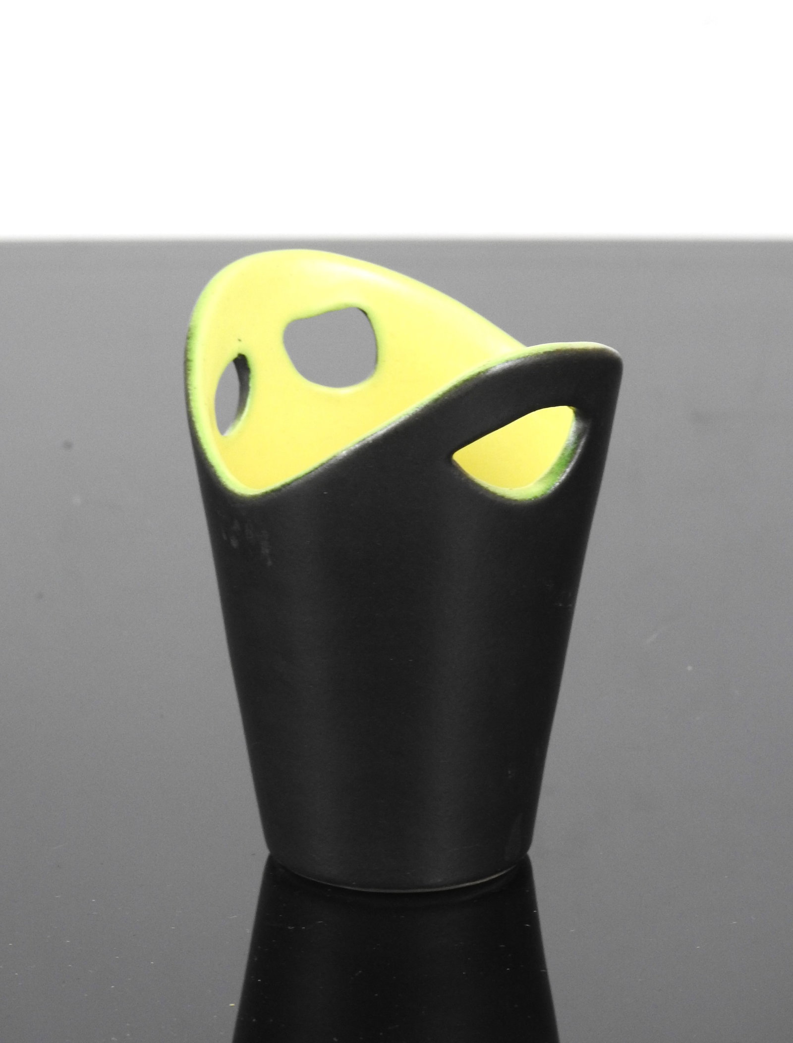 Pol CHAMBOST (1906-1983) Vase en ceramique emaille: Pol CHAMBOST (1906-1983)Vase en ceramique emaillee noir, interieur jaune, presentant trois trous. Marque made in FranceH 10 cm