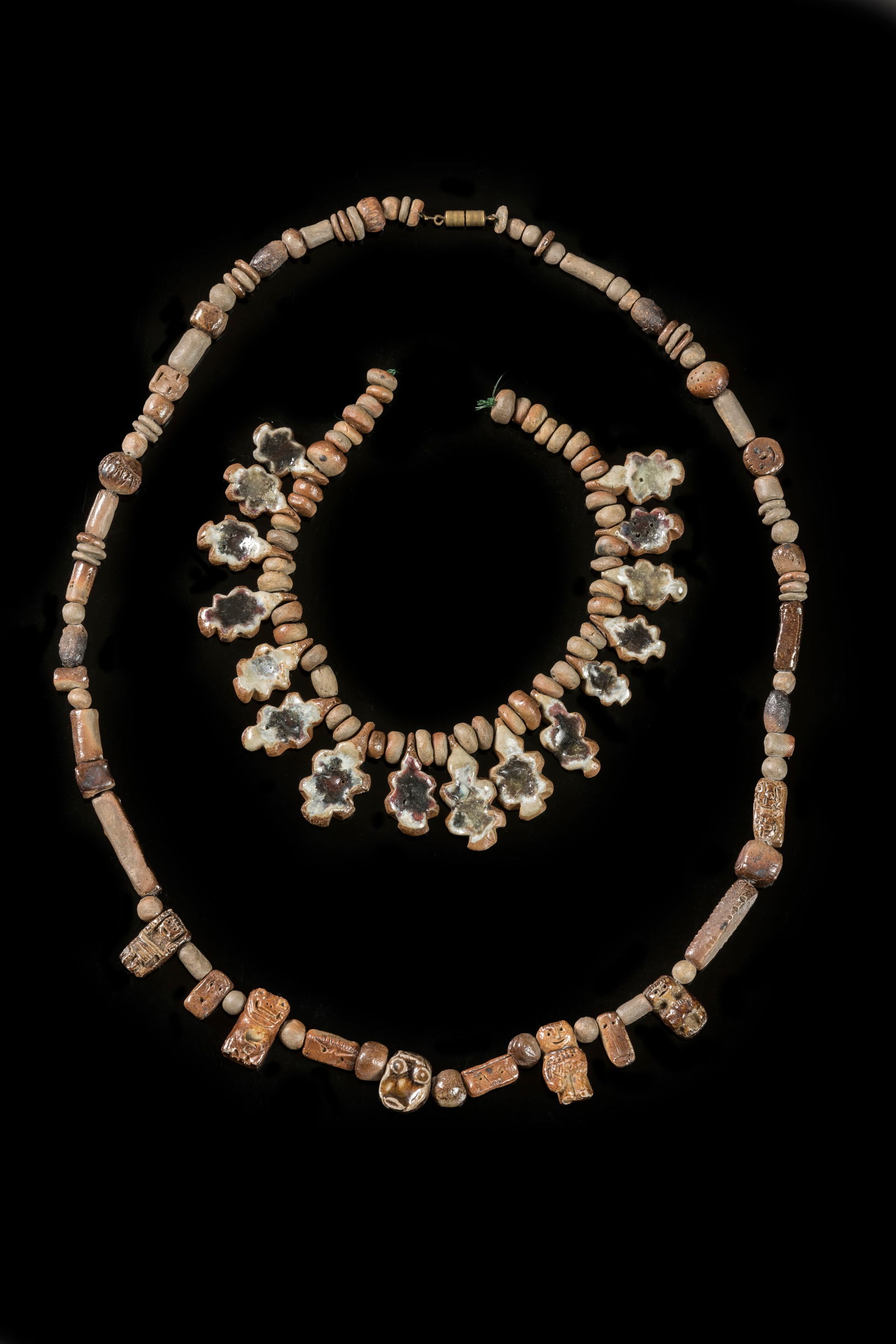 Jacqueline LERAT (1920-2009) Rare collier en perle: Jacqueline LERAT (1920-2009)Rare collier en perles de gres proteiforme dont certaines a decor de personnages.Signe et date 63L. : 68 cmOn y joint un autre collier en perles de gres en forme de feuille