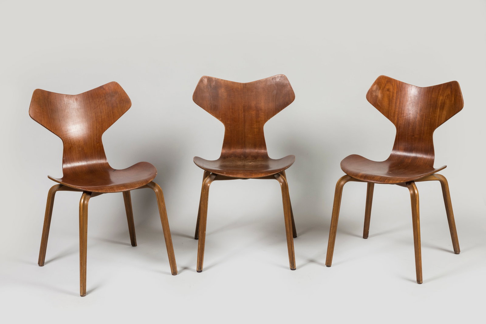 Arne JACOBSEN (1902-1971) Suite de trois chaises m: Arne JACOBSEN (1902-1971)Suite de trois chaises modele 4130 dit 'Grand Prix' en teckPorte au revers l'estampille sous l'assise Made by Denmark FH et l'etiquette Mobilier International pour l'une.H : 7
