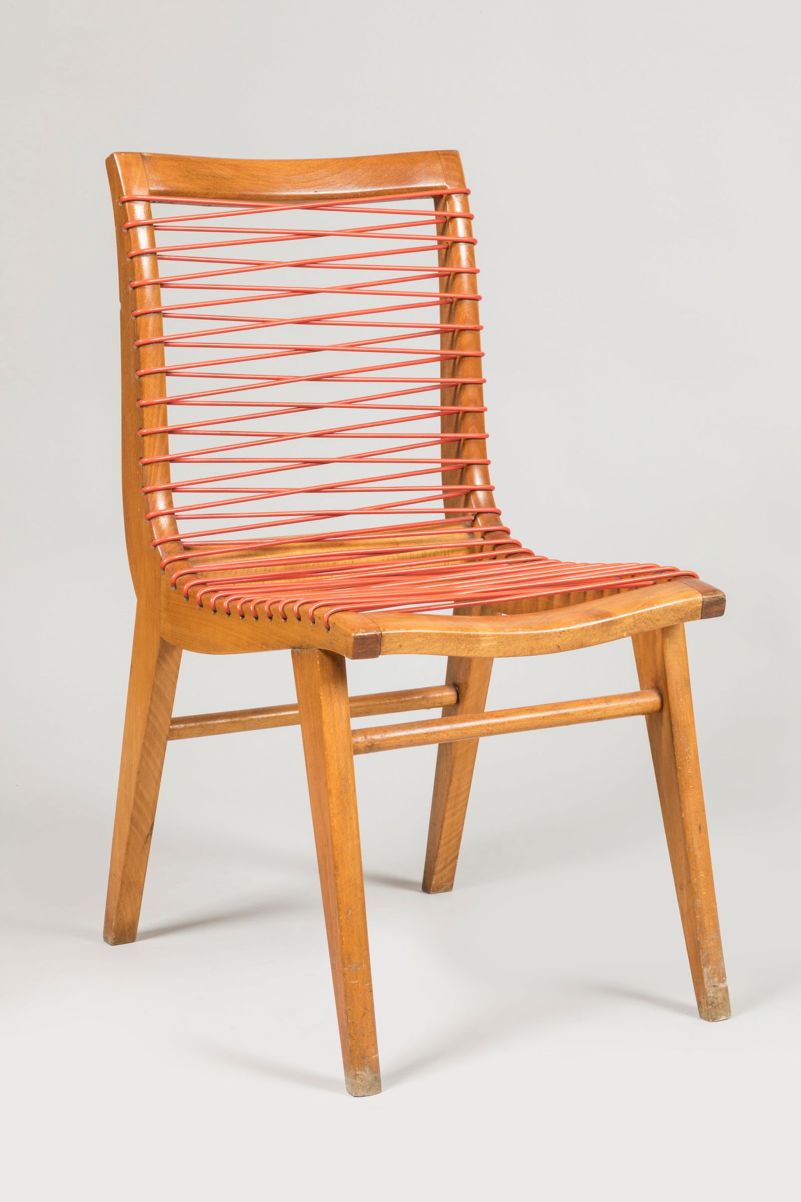 Louis SOGNOT (1892-1969) Chaise en hêtre vernis a: Louis SOGNOT (1892-1969)Chaise en hêtre vernis a assise incurvee sur pietement en equerre garnies de sangles en fils de SadroplastH. : 84 cmL. : 42 cmP. : 60 cmBel patine d'usage. Quelques marquesBib