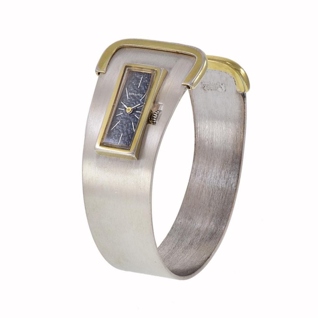 Longines Cuff Watch Sterling Silver: Longines Cuff Watch Sterling Silver and Vermeil Brand: Longines Case Material: Vermeil, Sterling Silver Strap Material: Silver Case Shape: Rectangle Movement: Manual Wind Case Diions: Height: 0.99