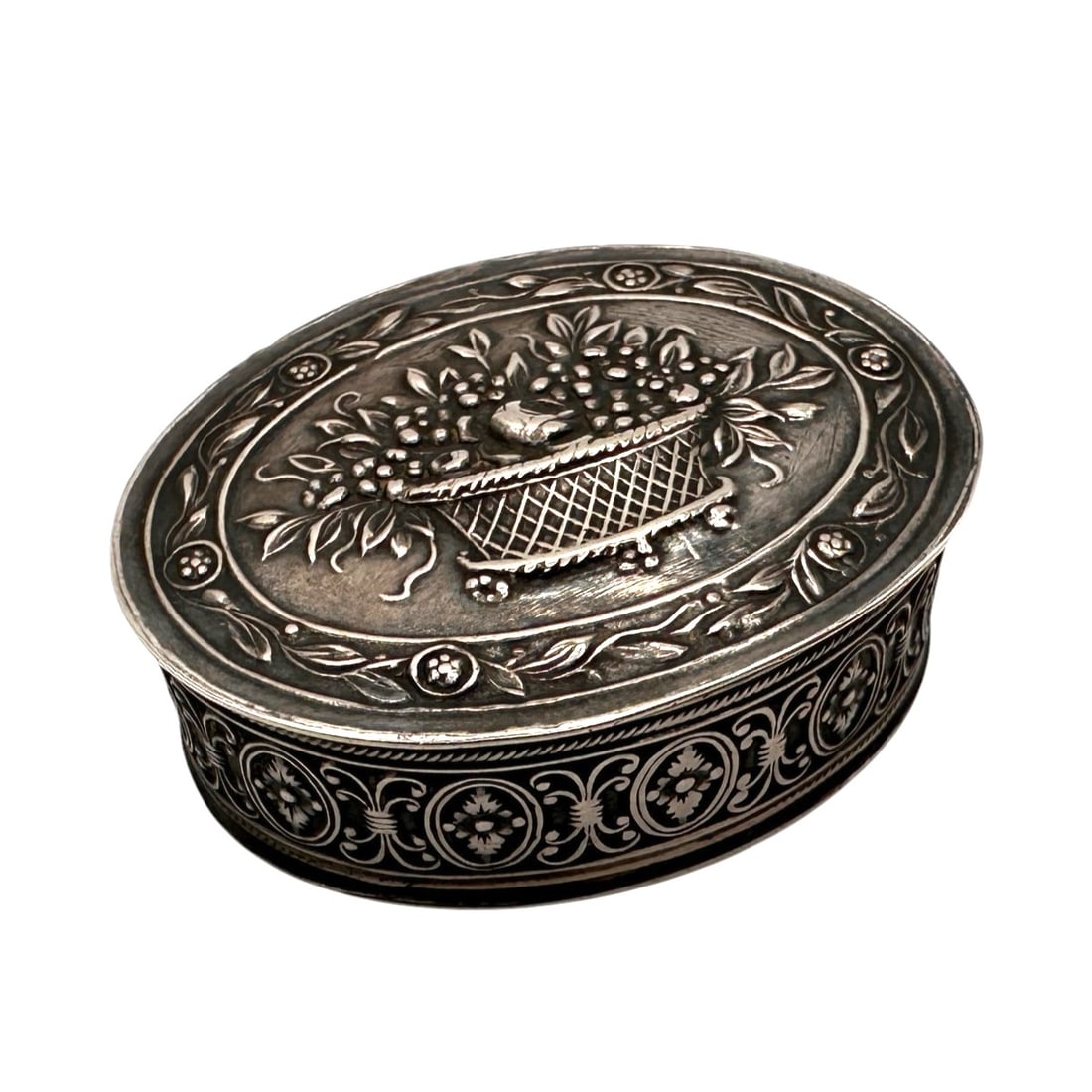 Vintage Sterling Silver Repouss? Trinket Box: Charming vintage sterling silver trinket box featuring an elegant oval form with richly detailed repouss? decoration. The hinged lid is adorned with a finely rendered basket overflowing with flowers a