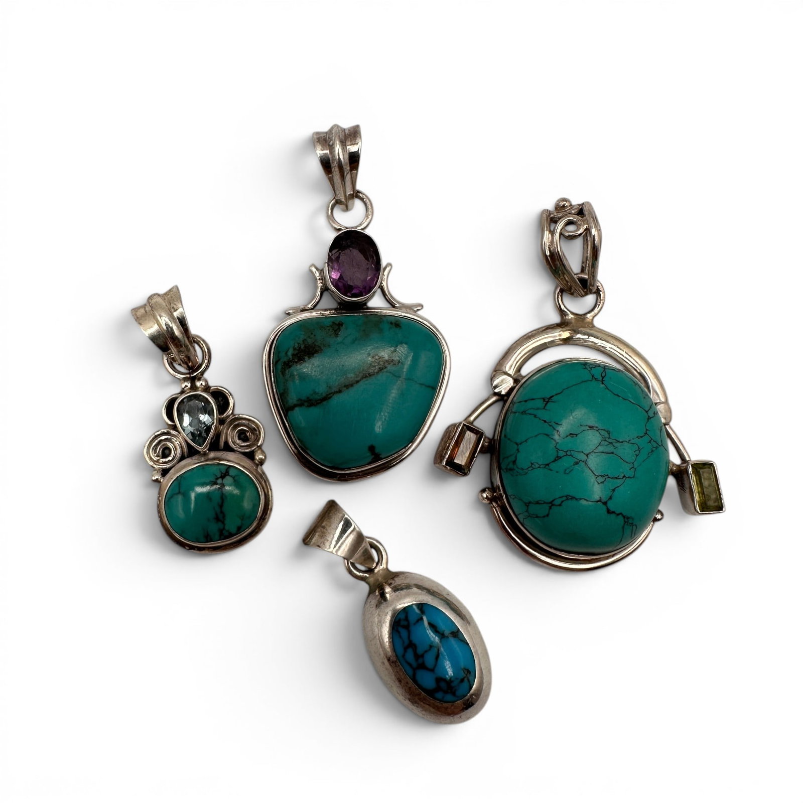 Collection of Sterling Silver Turquoise & Gemstone Pendants: A beautiful assortment of four sterling silver gemstone pendants featuring vibrant turquoise and complementary accent stones in a variety of artisan-crafted designs. This eclectic collection showcases