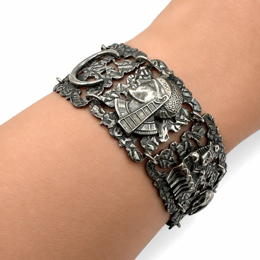 Vintage Egyptian Revival Panel Bracelet: Measures 8 1/2" long including extension chain. An unusual and highly detailed sterling silver bracelet featuring a series of openwork panels richly decorated with dimensional figural and symbolic mot
