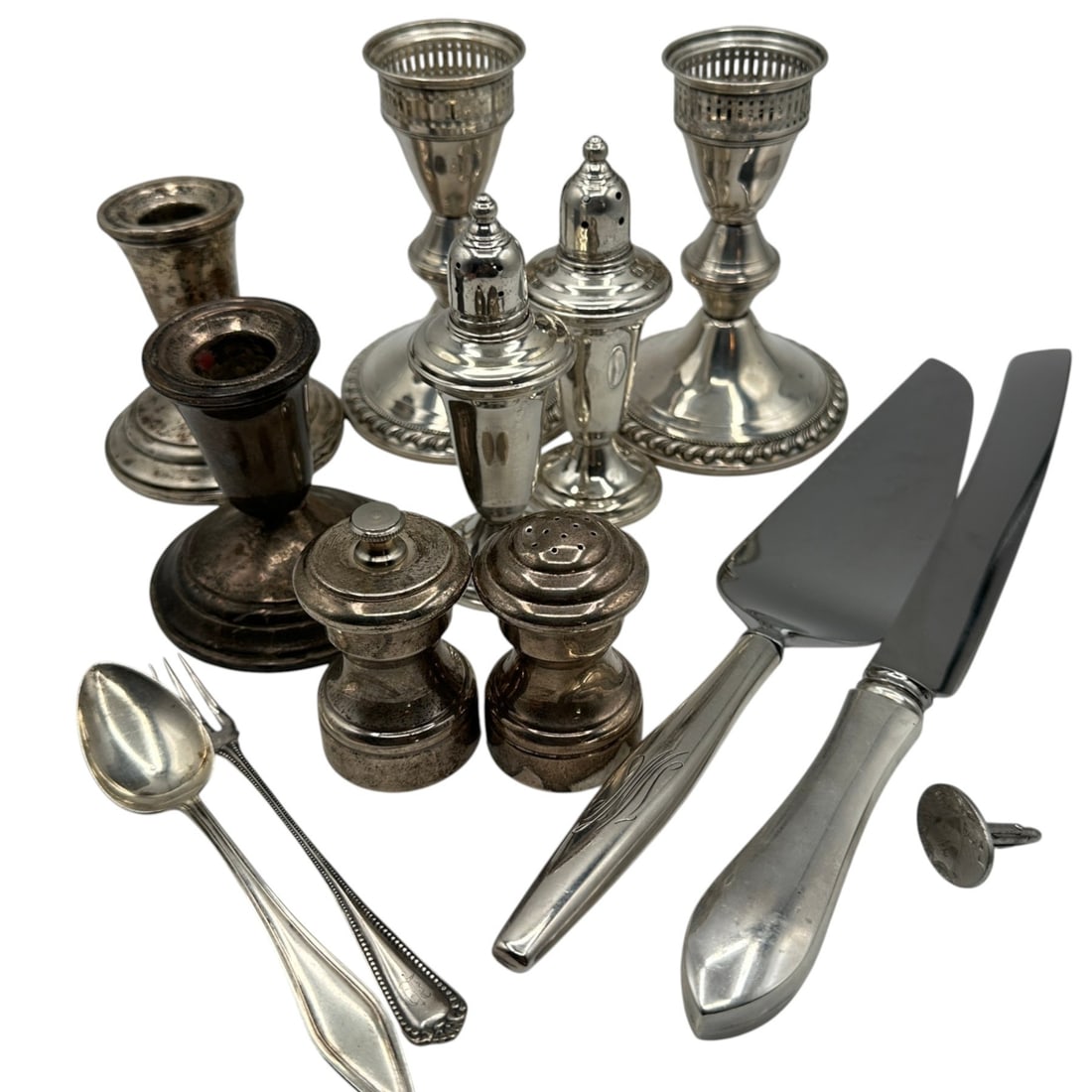 Mixed Lot of Sterling Silver Items: Silver spoon and fork weigh 32 grams. Empire sterling silver salt and pepper grinder (weighted) weighs 159 grams. Moire salt and pepper shakers (weighted) weigh 221 grams. Poole candlesticks (weighted