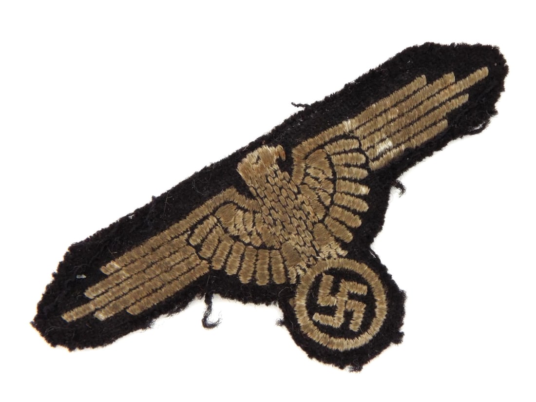 German WWII Waffen-SS Tunic Removed Sleeve Eagle: Mid war embroidered on black wool Waffen-SS sleeve eagle. This known and accepted variant SS sleeve eagle was uniform removed and still retains its original black imbedded stitching. Condition is soil