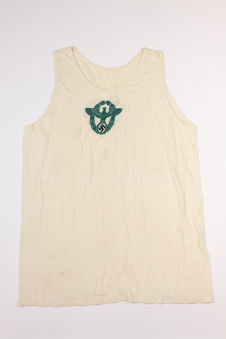 German WWII Police M35 Sports Shirt: German WWII Police M35 Sports Shirt.Police embroidered insignia sewn on an original M35 sport shirt. The insignia is machine woven in green and black threads over white cotton base. Overall in fine co