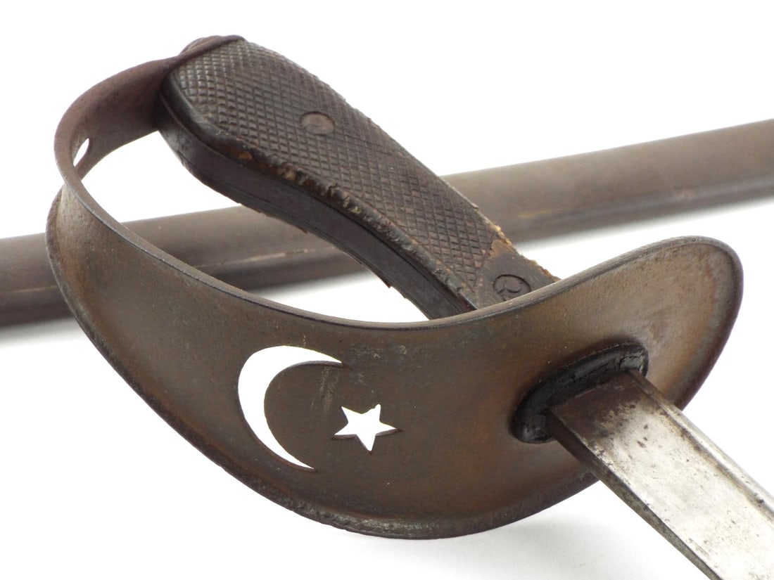 RARE Turkish WWI era Cavalry Officers Sword: Slightly curved, pipe-back blade, ricasso with Arabic inscriptions.Guard pierced with star and crescent, shaped grip with chequered composition grips, metal scabbard. Full Length 41 Inches Blade Lengt