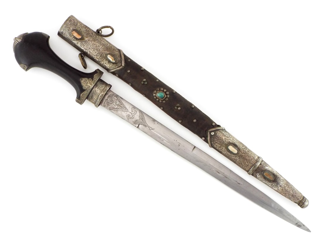 Ottoman Empire Balkan Silver Mounted Dagger Turquoise & Coral Cabochons: Dagger exhibiting quality silver mounts throughout. Double edged blade displays engraved foliage panels with soft greyish patina and light runner marks. Dark hardwood grip remains solid, framed by