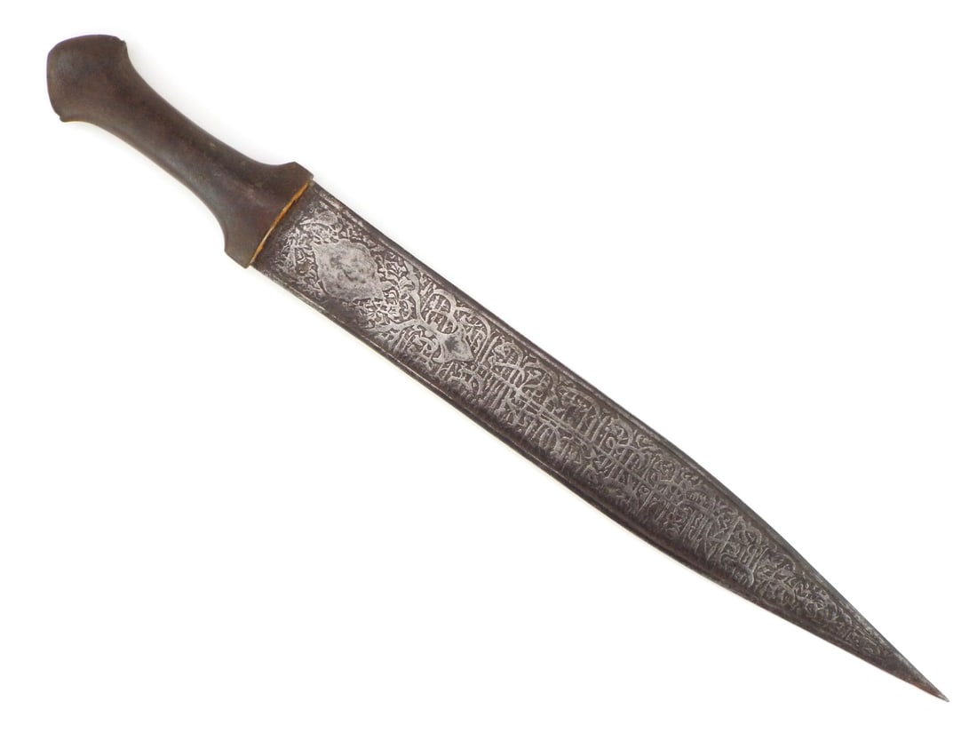 19th C. Islamic Kinjal Dagger: 19th C. Islamic Dagger. Displays rugged elegance with a convex, double edged blade terminating in a sharp pointed tip, featuring engraved Islamic phrases, showing grey patina but remaining solid. The