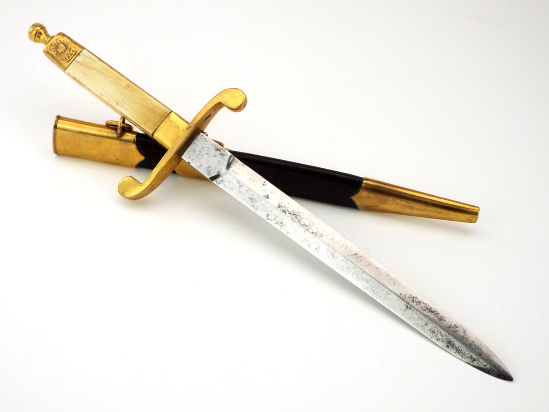 Rare Imperial Russian Provisional Government Navy Officers Dagger: Double edge blade showing light grey patina. Gilded brass mounts exhibiting mellowed surfaces, grip carved from elephant with cream mellowing beneath stamped pommel. The wooden scabbard retaining blac