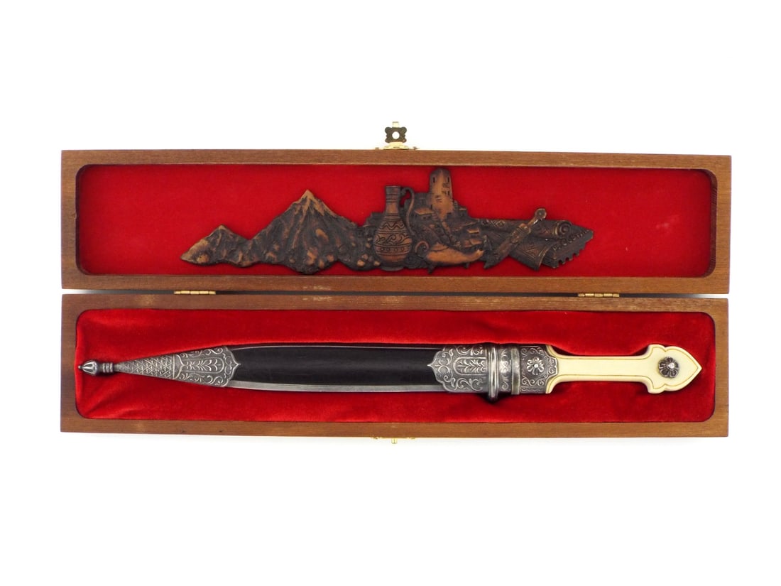 Cased Caucasian Russian KINDJAL Dagger: Russian Caucasian (Dagestani) kindjal. Double edged blade with twin channels in very fine condition. Complete with fitted wooden display case in red velvet interior and wood carving displaying Dagesta
