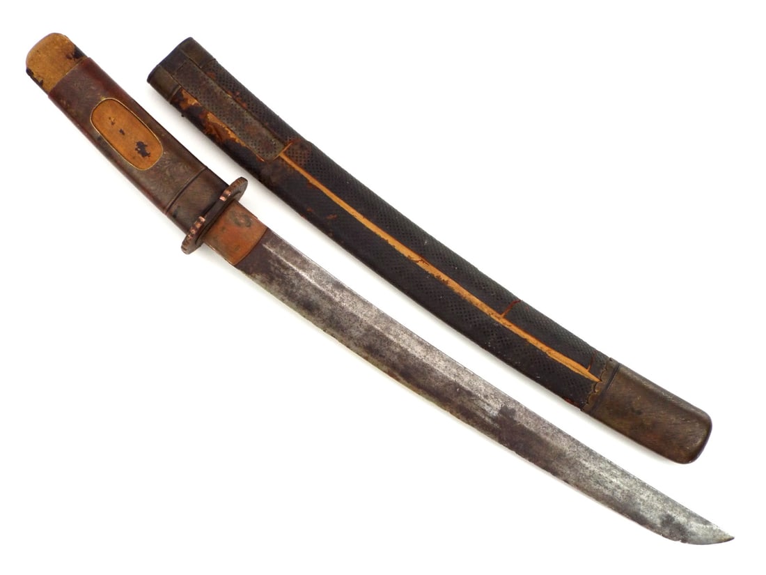 Meiji Period Japanese TANTO Blackened Samegawa: Meiji period Japanese tanto featuring a single edged curved blade under dark patina etched by time yet parting the wind with a serrated coldness. Wood hilt boasts a decorative brass sleeve with