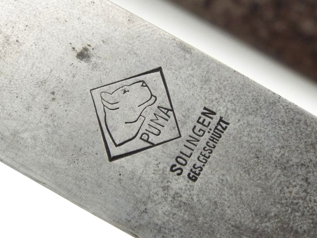 Early German WWII HJ Knife RZM M7/27 By PUMA SOLINGEN 1936: Single edged blade exhibits a mellowed patina and the "Blut und Ehre!" motto translating to "Blood and Honor" engraving, featuring both the Puma Solingen logo and RZM M7/27 markings for 1936. The hilt