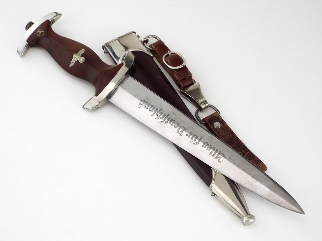 German WWII SA Dagger CARL EICKHORN SOLINGEN & Leather Hanger: SA service dagger features a fine double edged blade exhibiting the vivid "Alles fur Deutschland" engraved motto translating to "All for Germany" alongside the Carl Eickhorn squirrel trademark and RZM