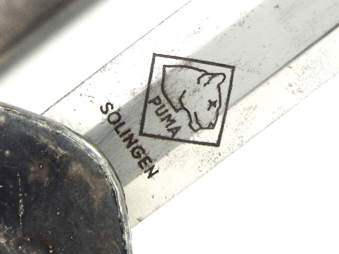 German WWII Army Officer Dagger PUMA SOLINGEN Silvered Mounts: Double edged stiletto blade with a fine matte luster, localized oxidation and a crisp PUMA SOLINGEN maker's mark engraved to the reverse ricasso. The silvered hilt is composed of a well detailed cross