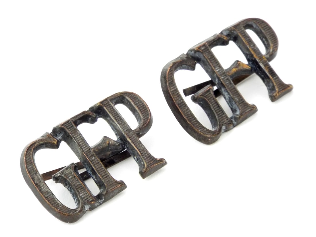 German WWII Wehrmacht SHOULDER GFP CYPHERS GEHEIME FELDPOLIZEI: Pair of shoulder board cyphers of the Geheime Feldpolizei, the Wehrmacht's feared Secret Field Police. Each cypher is die stamped from wartime Kriegsmetall, likely zinc alloy, with the distinctive ser