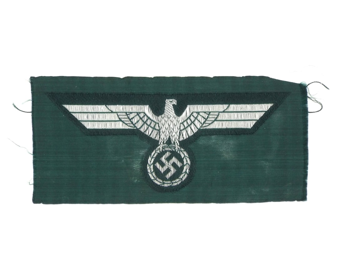 German WWII ARMY BREAST EAGLE Bevo Woven Silver Rayon Thread: Heer pattern breast eagle displays a silver grey rayon thread construction on a fine dark bottle green backing. The BeVo weave remains tight with no significant fraying to the internal embroidery. Dis