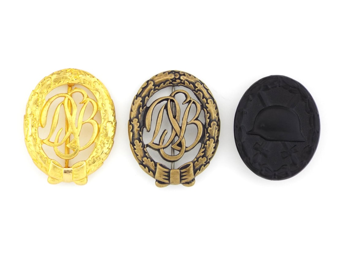 German WWII BADGE GROUP: Lot comprises two die struck openwork sports badges and one solid black wound badge. Gilt and bronze examples show minor high point wear with intact pin assemblies, overall in very good condition, rev