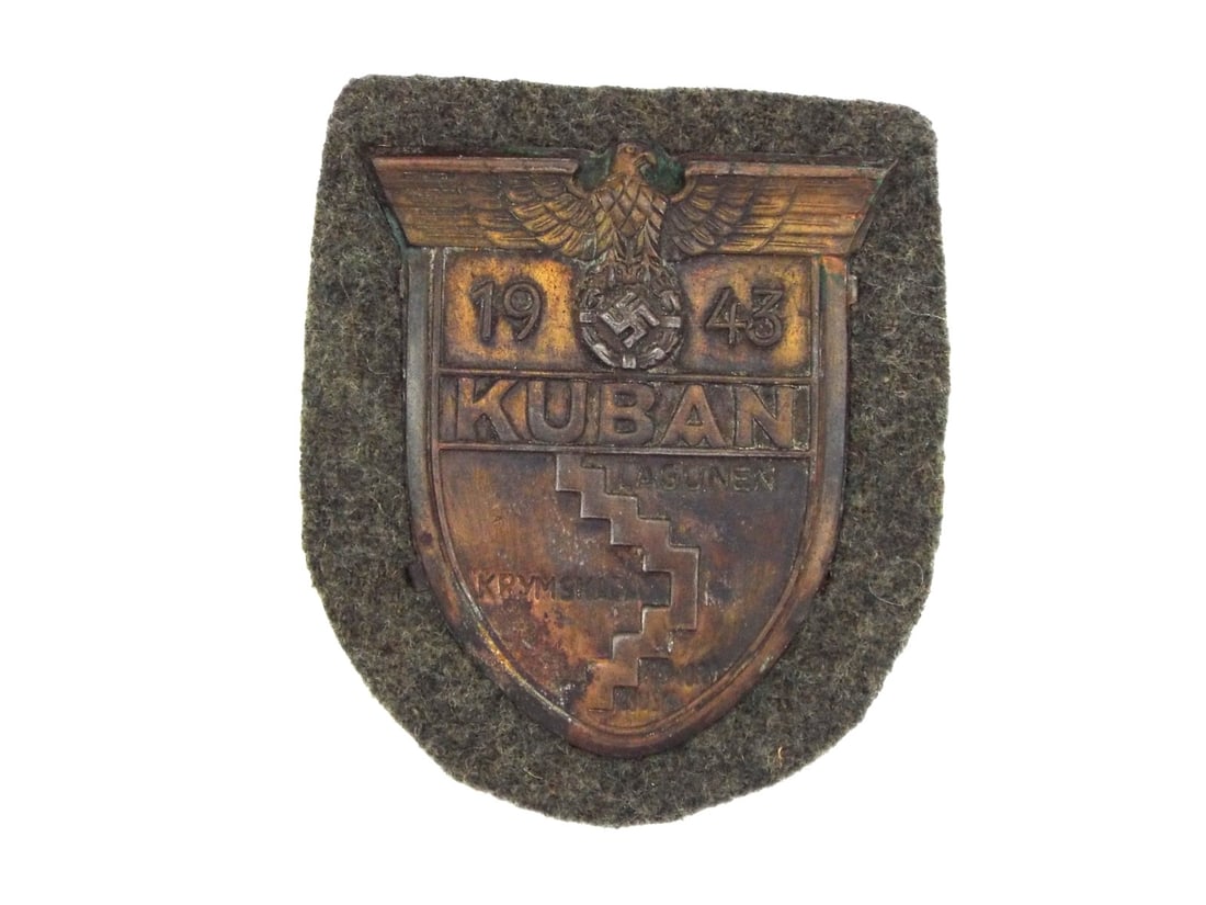 German WWII KUBAN SHIELD On Field Grey Wool: Displays heavy bronze wash loss with dark tarnish and oxidation to the recessed map detailing showing Lagunen, Krymskaja and Noworossijsk. The 1943 dated shield retains crisp definition to the eagle a