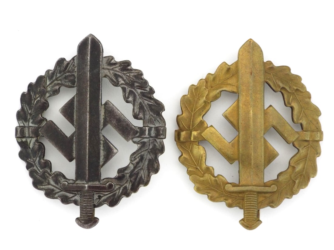 Pair of German WWII SA SPORTS BADGES: Bodies exhibiting moderate surface oxidation and thinning. Wreath details remain crisp with light high point wear. Integral hinges and pins are functional with original tension and minimal distortion