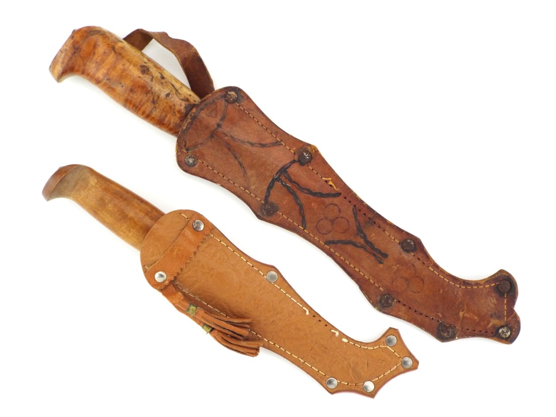 Pair of Scandinavian WWII Era SAMI PUUKKO Hunting Knives: large hunting blade displays moderate oxidation and decorative scroll engraving near the spine, smaller blade shows minor surface scratches with sharp grind and J.A. HELLBERG ESKILTUNA stamp. Both han