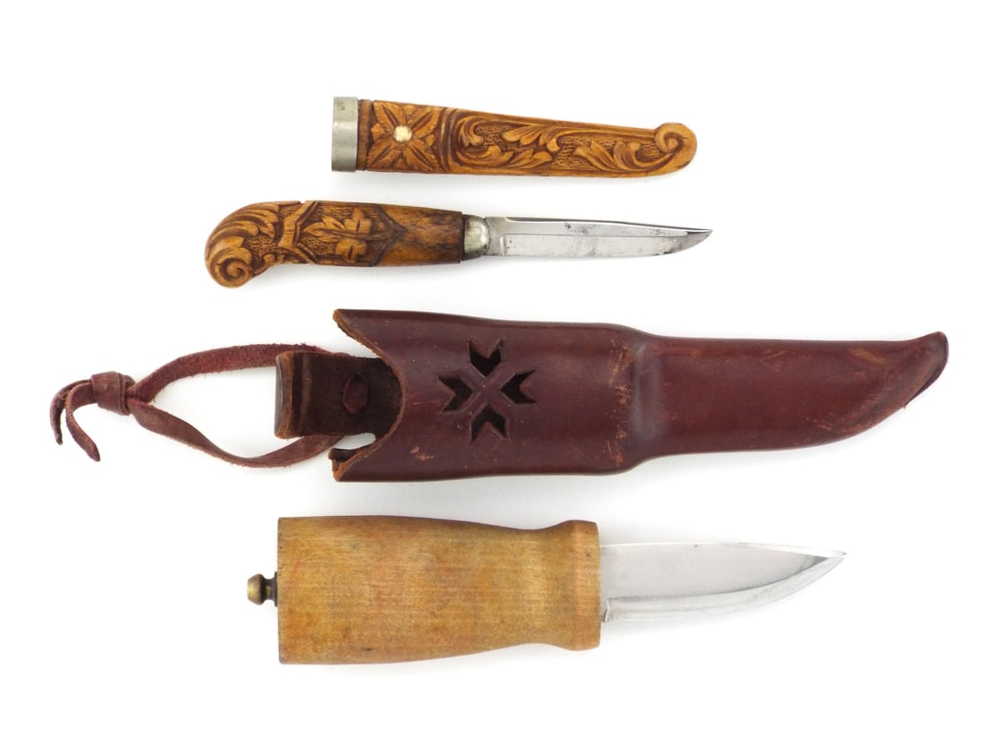 Pair of Norwegian WWII Era Carved Knives with Scabbards: Tapered Helle stainless steel blade paired with a carved blade displaying spotty oxidation. Large birch grip exhibits smooth handling wear while small handle features intricate acanthus relief. Includ