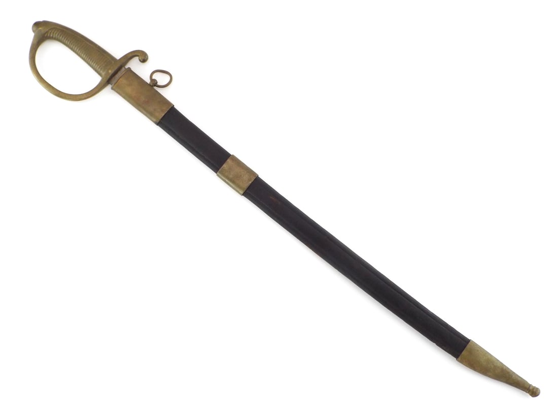 German WWI Artillery Short Sword W.K.C. With Leather Scabbard: Heavy straight blade shows scattered oxidation with clear maker mark at ricasso. Solid brass hilt remains tight with deep mustard patina and minor handling marks to the ribbed grip. Leather scabbard e
