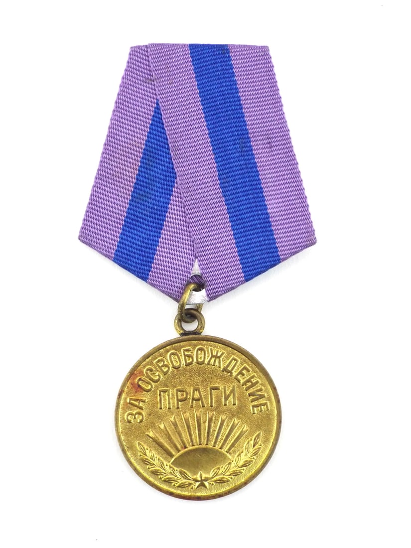 Soviet WWII LIBERATION OF PRAGUE MEDAL with Ribbon: Brass planchet displays characteristic pebbled reverse field with age consistent toning and minor surface oxidation. Obverse inscription translates to FOR THE LIBERATION OF PRAGUE, remains crisp above