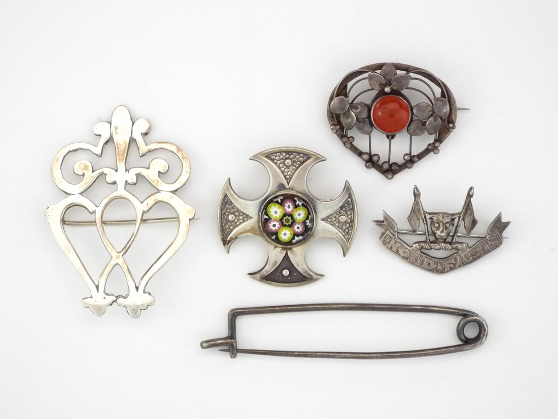 Scottish & British Clan Brooch Collection SILVER: Diverse quintet of silver brooches comprising an Edwardian millefiori glass cross with Chester hallmarks for CHARLES HORNER, an Arts and Crafts openwork heart form set with a carnelian cabochon, and a