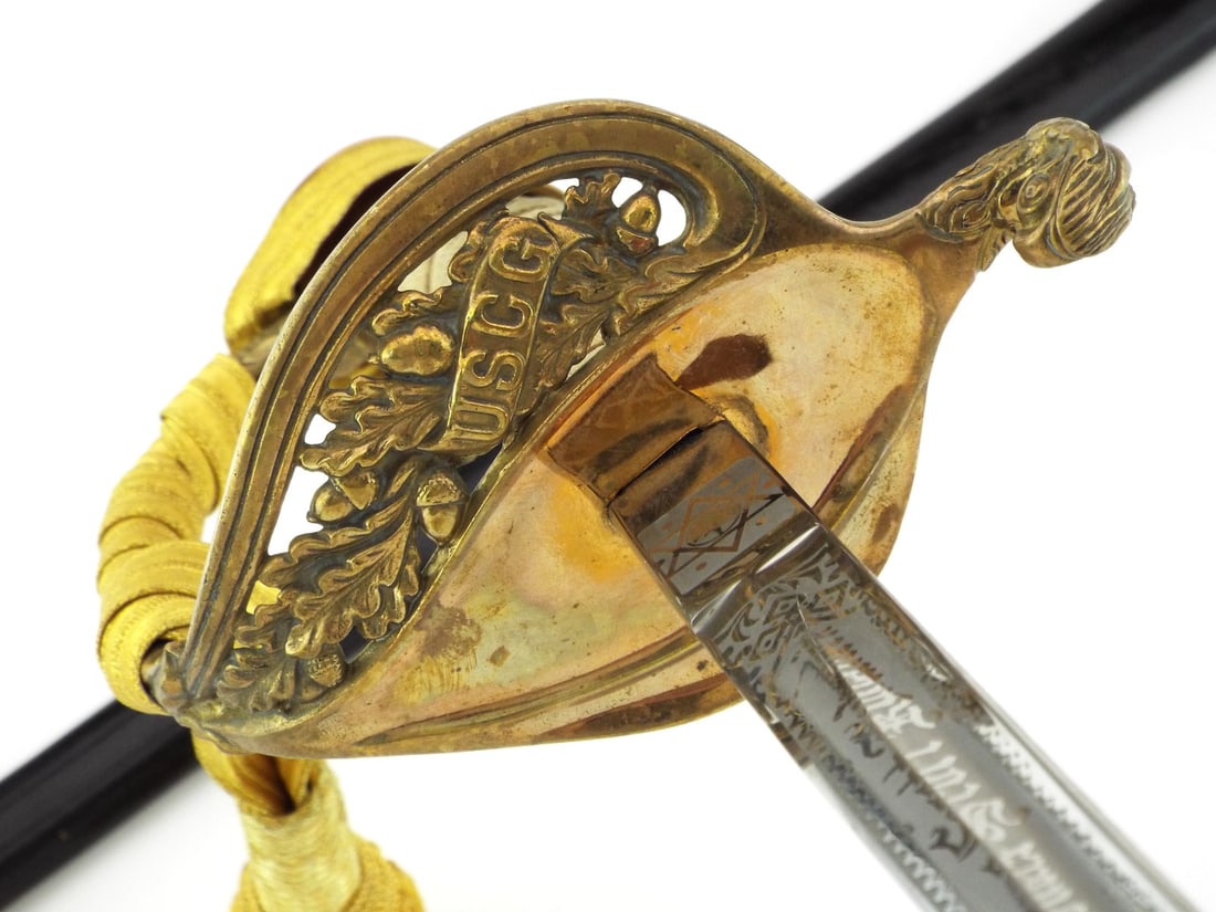 Rare US WWII to Vietnam War Era USCG OFFICER SWORD By N.S. MEYER SOLINGEN: Stainless steel blade exhibits crisp engraved scrolls and USCG scroll, featuring the N.S. Meyer Conqueror West Germany ricasso mark. Gilt brass guard shows light surface patina with distinct oak leaf 