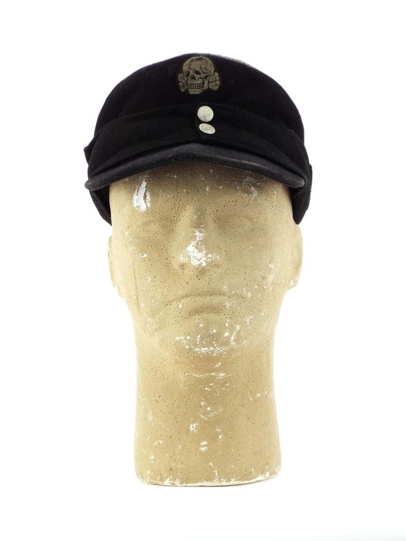 German WWII SS OFFICER FIELD CAP with Totenkopf & Silver Piping: Waffen-SS black wool body shows moderate surface nap wear. Top crown features silver aluminum bullion piping indicating officer rank. Front displays machine woven death head insignia with side mounted