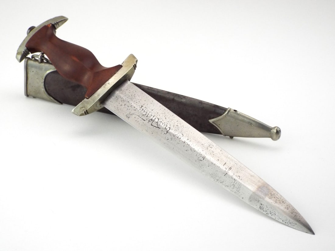 German WWII SA Dagger by CARL EICKHORN with Ernst Rohm Inscription: Standard double edged blade displays heavy salt and pepper oxidation throughout with legible Alles fur Deutschland motto and Ernst Rohm In herzlicher Kameradschaft - In heartfelt comradeship dedicatio