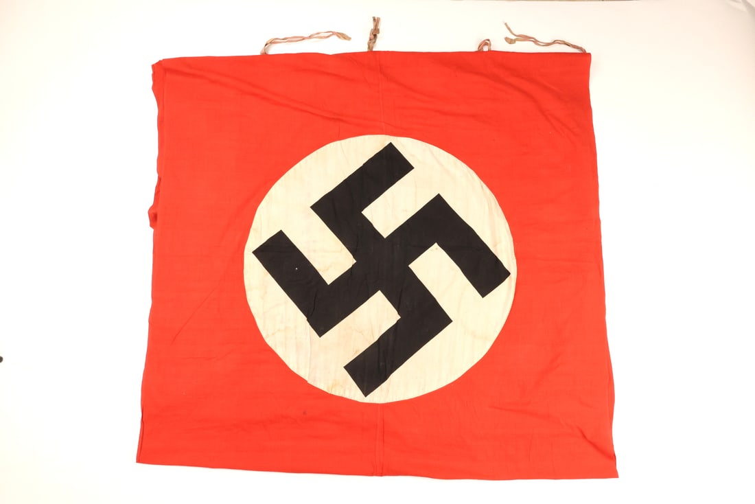 Huge German WWII PODIUM BUILDING BANNER with Intact Mounting Ties: Red cotton field exhibiting moderate surface soiling and age toning. Multi piece construction features a machine stitched white roundel with an applied black ensign. Some moisture staining and light f
