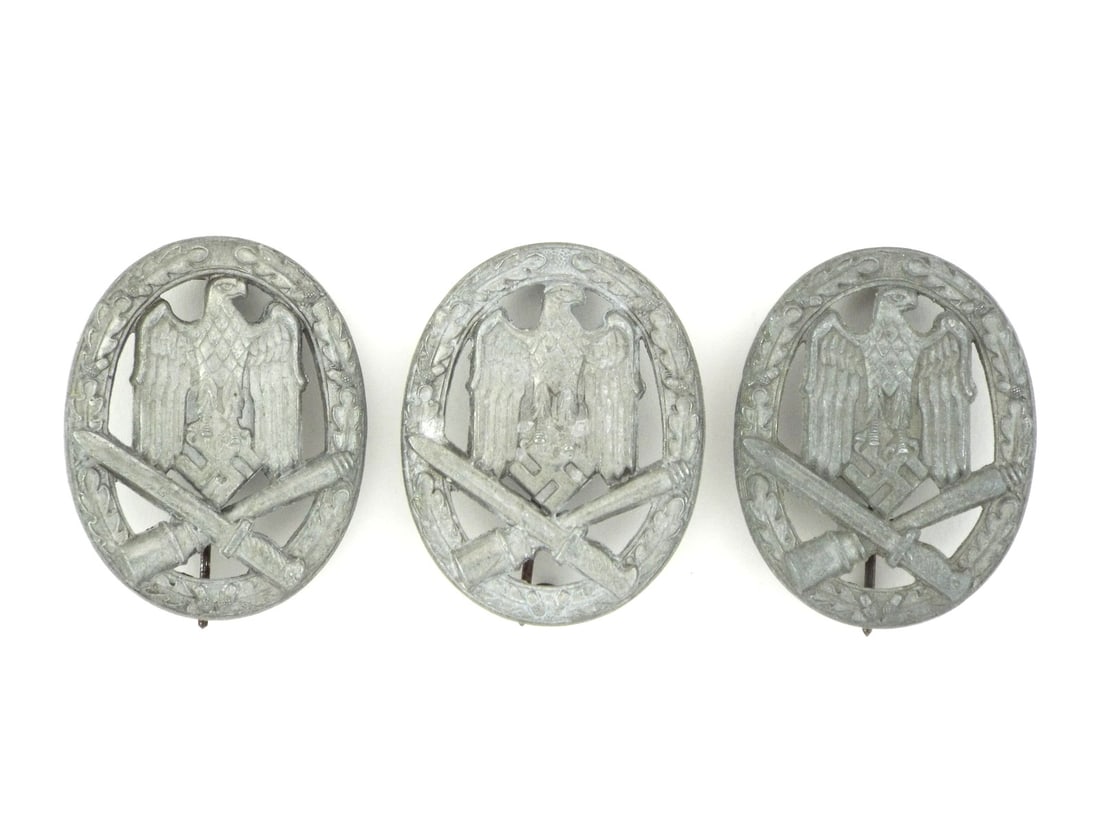 Lot of Three German WWII GENERAL ASSAULT BADGES: Lot of three die struck zinc badges exhibiting characteristic gray oxidation. Each badge retains sharp detail to the oak leaf wreath and central eagle motif. Reverse features hollow back construction 