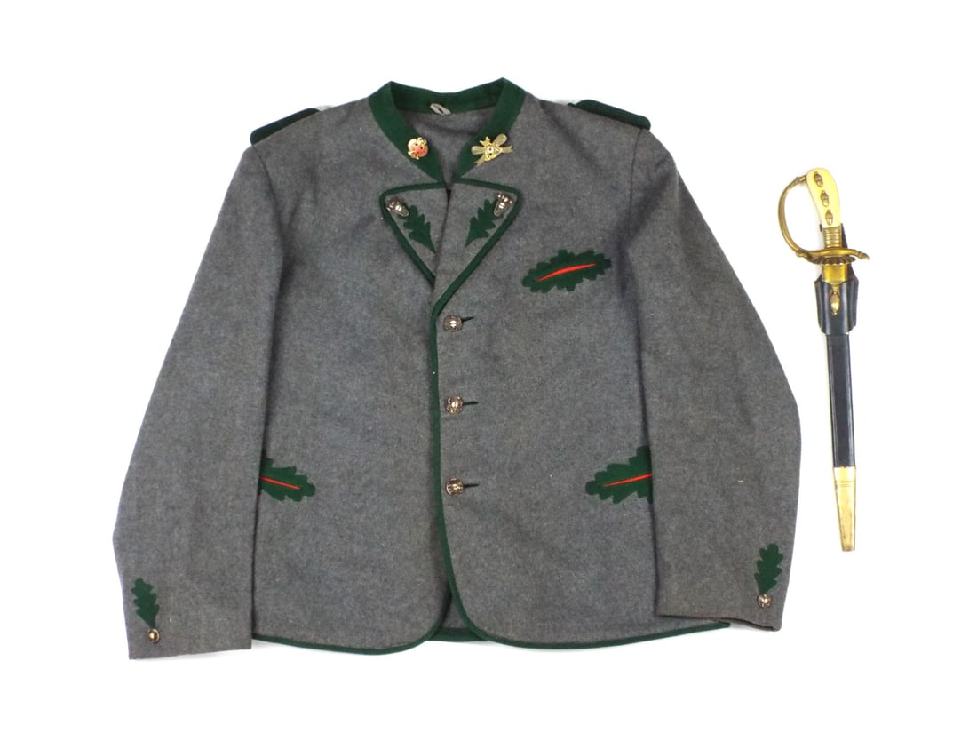 German WWII Forestry Tunic and Hunting Sword By CLEMEN & JUNG SOLINGEN: Etched carbon steel blade features hunting scenes with prominent Z in shield maker mark, showing light peppering and crisp frosting. Gilt brass hilt exhibits honest patina with clamshell guard and Ver