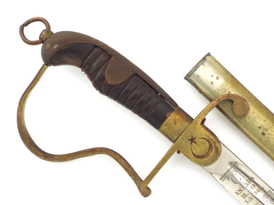 Turkish Republic WWII Military Academy Officer Sword ATATURK ARMY: Slightly curved blade features floral etching, the star and crescent and Republic of Turkey Ankara Military Academy 1.3.1940 inscriptions with minor surface oxidation. Brass stirrup hilt shows heavy p