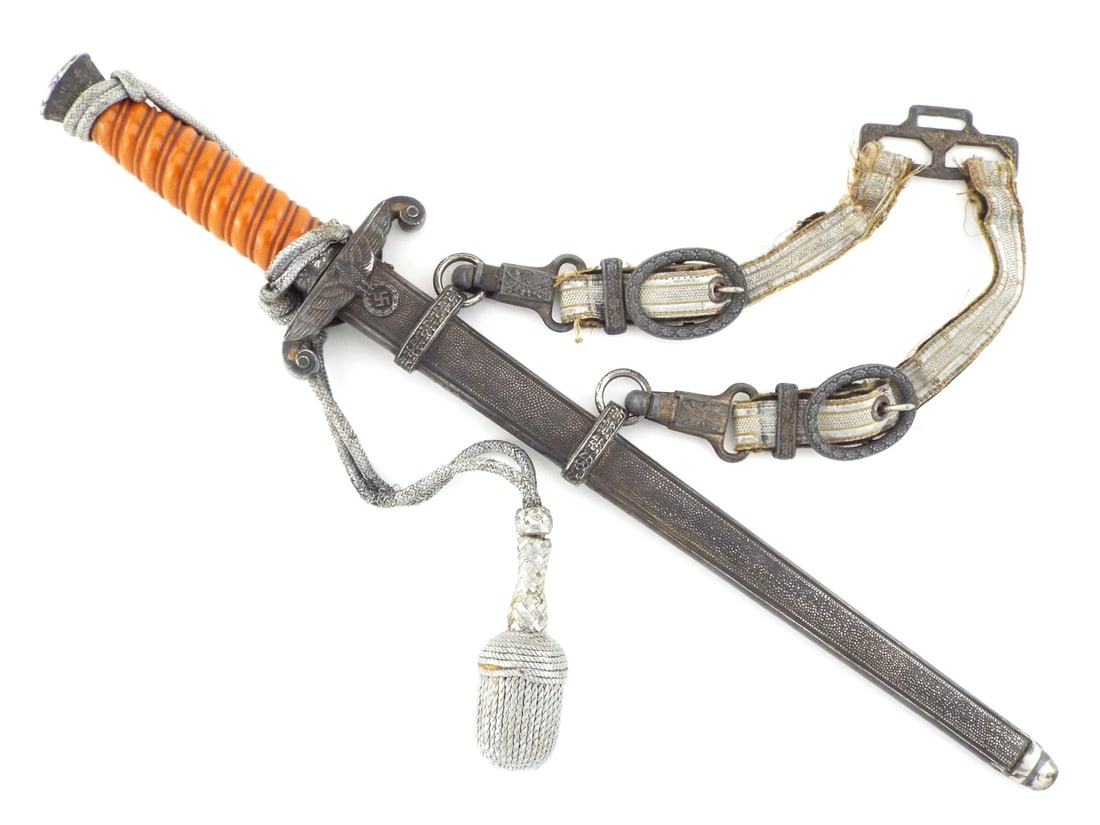 Rare German WWII Army Officer Dagger WKC SOLINGEN & Deluxe Hangers: Double edged blade remains bright with a crisp Knight Head hallmark. Cast zinc crossguard and oak leaf pommel exhibit heavy dark patina and moderate surface oxidation. Deep orange celluloid grip is so