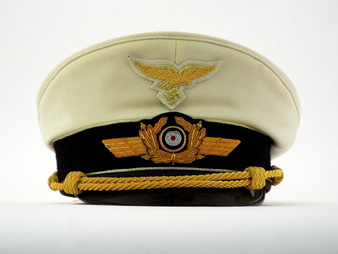 Very Good Quality German Made POST WWII Summer Luftwaffe General Visor Cap: High quality summer service cap features off white wool body with gold bullion wire Luftwaffe eagle and wreath. Black mohair band displays centered tri color cockade. Double gold bullion chin cords se