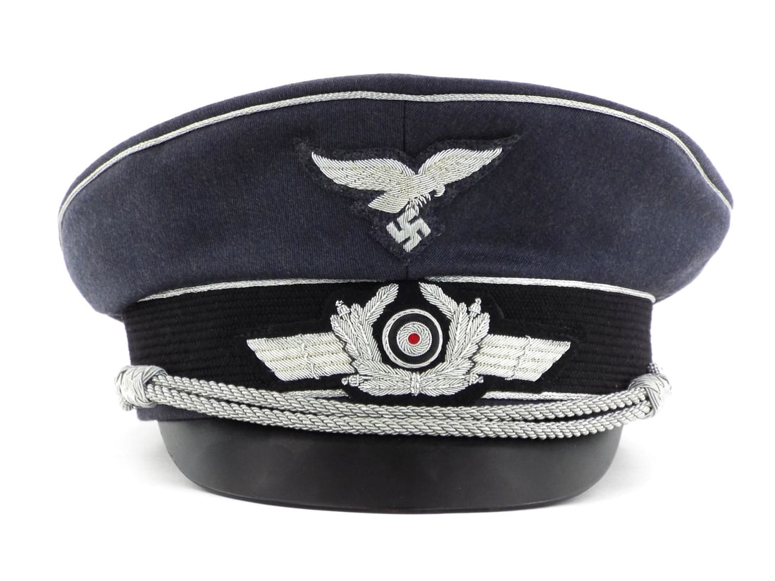 Very Good Quality German Made POST WWII LUFTWAFFE Officer Visor Cap: Constructed of blue grey wool body with silver bullion embroidered eagle and winged wreath. Bullion shows no oxidation or tarnish. Interior features yellow rayon lining with maker stamp for Luftwaffe 