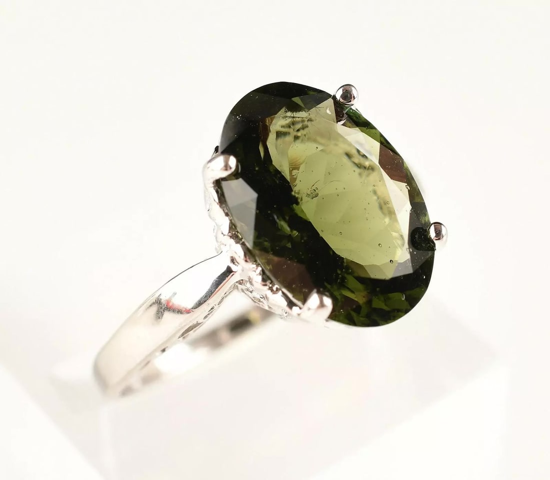 Elegant 14kt White Gold Moldavite Ring Size 9. New: Stone : 14mm x 10mm. Size: 9. Weight : 4.1g. Marks : 14k. Direct credit card payment will not be accepted for this Lot. Accepted payment methods include cash, certified bank check, wire transfer, and 