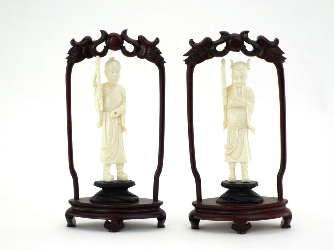 Very Fine Pair of Chinese CARVED IMMORTALS in Dark Wood Arch Stands: Paired carved Very Fine immortals exhibiting light honey patina. Fine vertical striations present throughout the robes with minimal surface wear. Figures mounted to tiered black bases within rosewood 