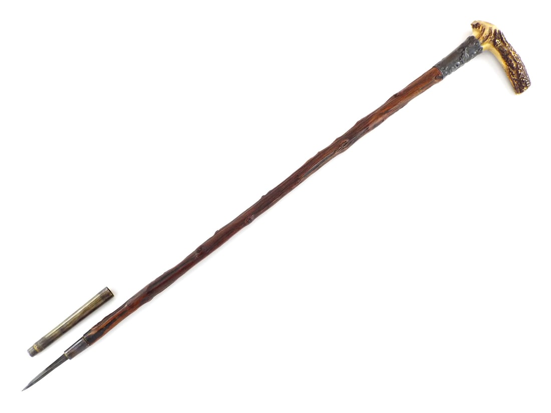 Rare US Civil War American Made CANE with Hidden Lethal Spike: Concealed 3 inch steel spike exhibits dark oxidation. The shaft is a robust, figured wood with a natural knobby texture showing light surface scuffs. The handle is a carved stag horn L-shape with a vi