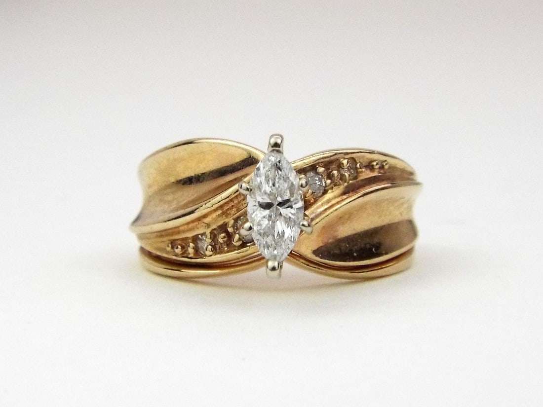 BRIDAL Ring 10K GOLD & Marquise Diamond: Nested bypass style 10k yellow gold body displays moderate surface oxidation and expected pocket wear to the 3.4 gram shank. Six prong white metal head secures a 0.30 ctw marquise cut diamond center f