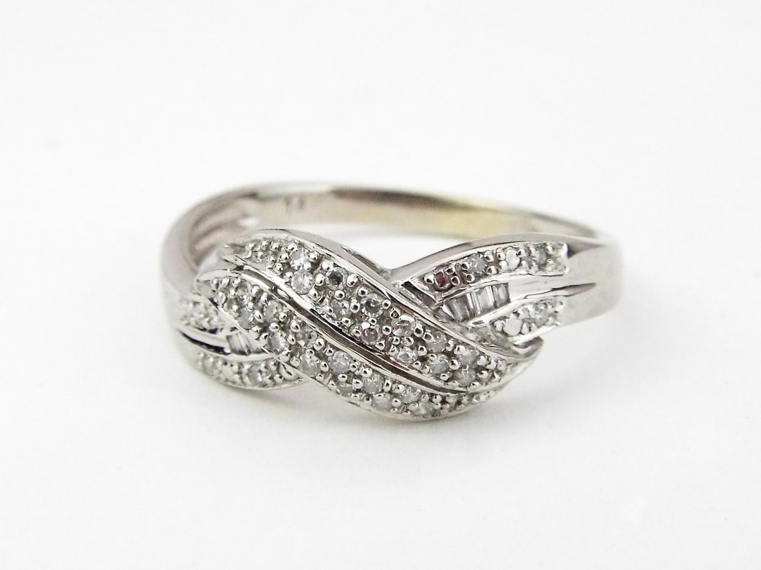 CROSSOVER Ring 14K WHITE GOLD & DIAMONDS: Low profile crossover form body of 14K white gold exhibiting minor surface abrasions and light patina. Setting features two interlocking bands set with 0.50 ctw of round brilliant and baguette cut dia