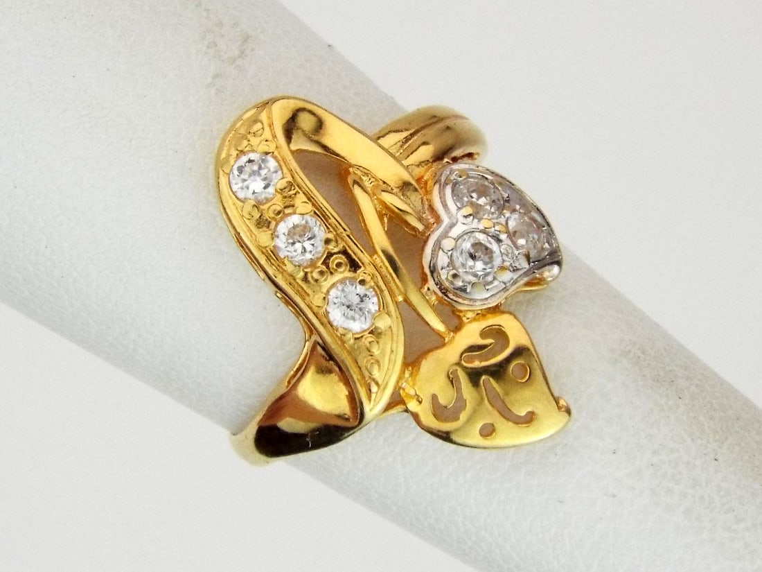 Heart Ring 21K GOLD & Cubic Zirconia: Cast 21 karat gold bypass body displays high luster finish with open work scalloped heart and foliate motifs. Surface exhibits minor handling wear and consistent yellow hue. Round cut cubic zirconia s