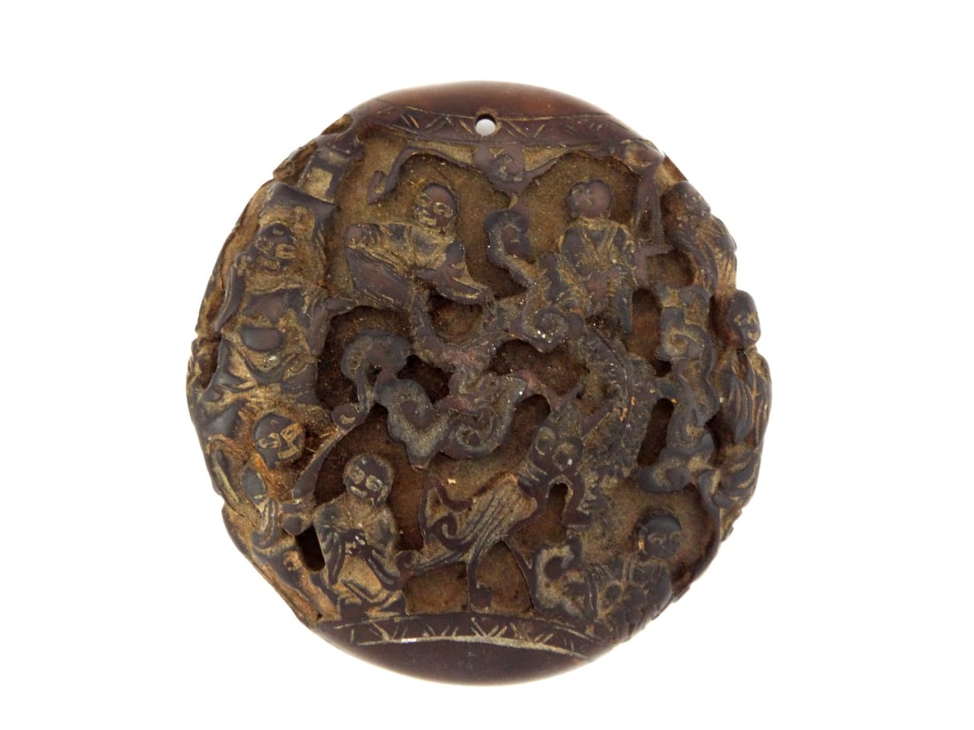 Chinese Late Qing Pierced HORN ROBE ORNAMENT with Figural Carving: Carved horn robe ornament with double sided openwork decoration depicting buddhist figures, dark brown translucent material showing age patina and handling wear, pierced suspension aperture at rim, re