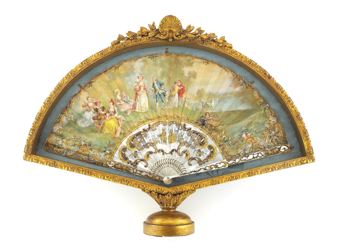 French Victorian Hand Fan Hand Painted with EXTENSIVE MOTHER OF PEARL & Gilding: Hand painted silk leaf body features a pastoral 18th century courting scene, signed by the artist, with minor age wear at folds. Pierced mother of pearl inner sticks and outer guards display heavy gol