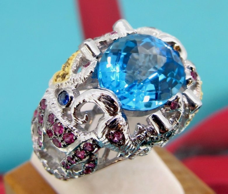 12mm x 9mm Blue Topaz 18k White Gold Multi-Colored Gemstones Cocktail Ring 6.75.: Width approx From 5 mm to 17mm. Metal 18k White Gold. Blue topaz approx 12mm x 9mm. Weight 14.70 grams. Size 6 3/4 Direct credit card payment will not be accepted for this Lot. Accepted payment method